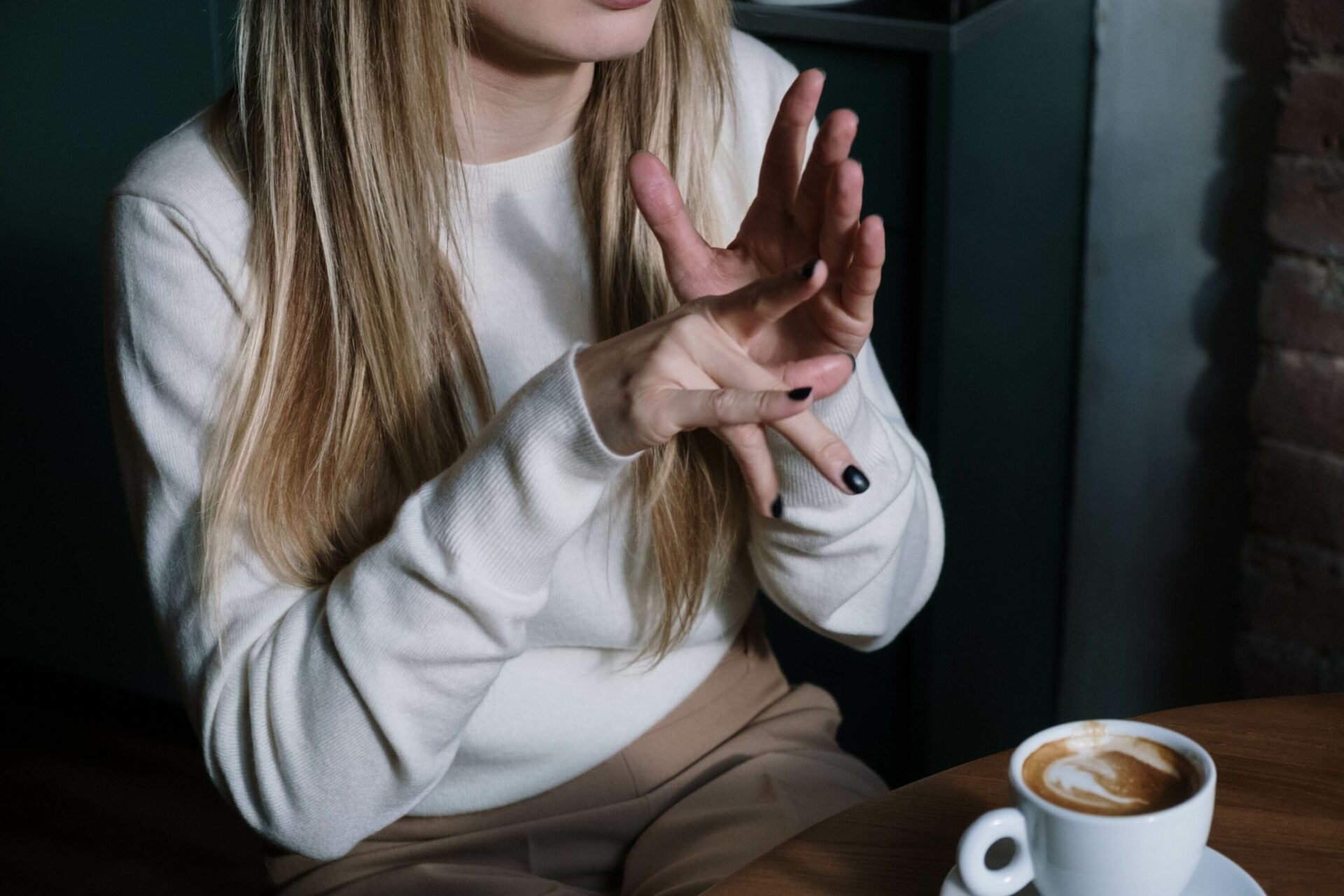 Woman with coffee learning sign language