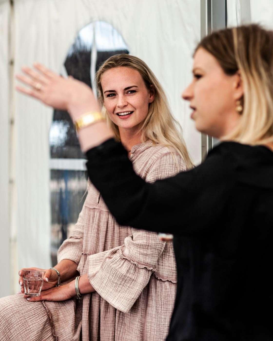 A woman watching another woman who is signing