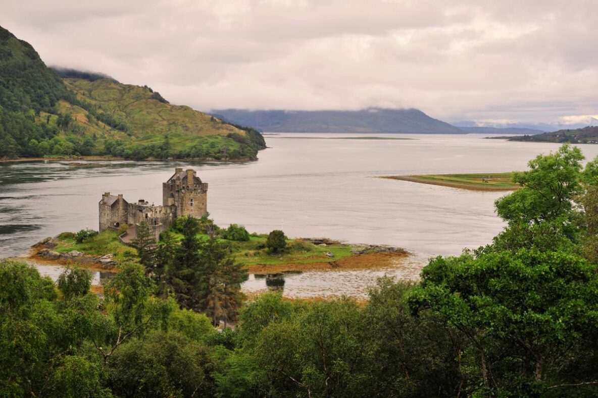 A picture of a castle on the shores of a loch