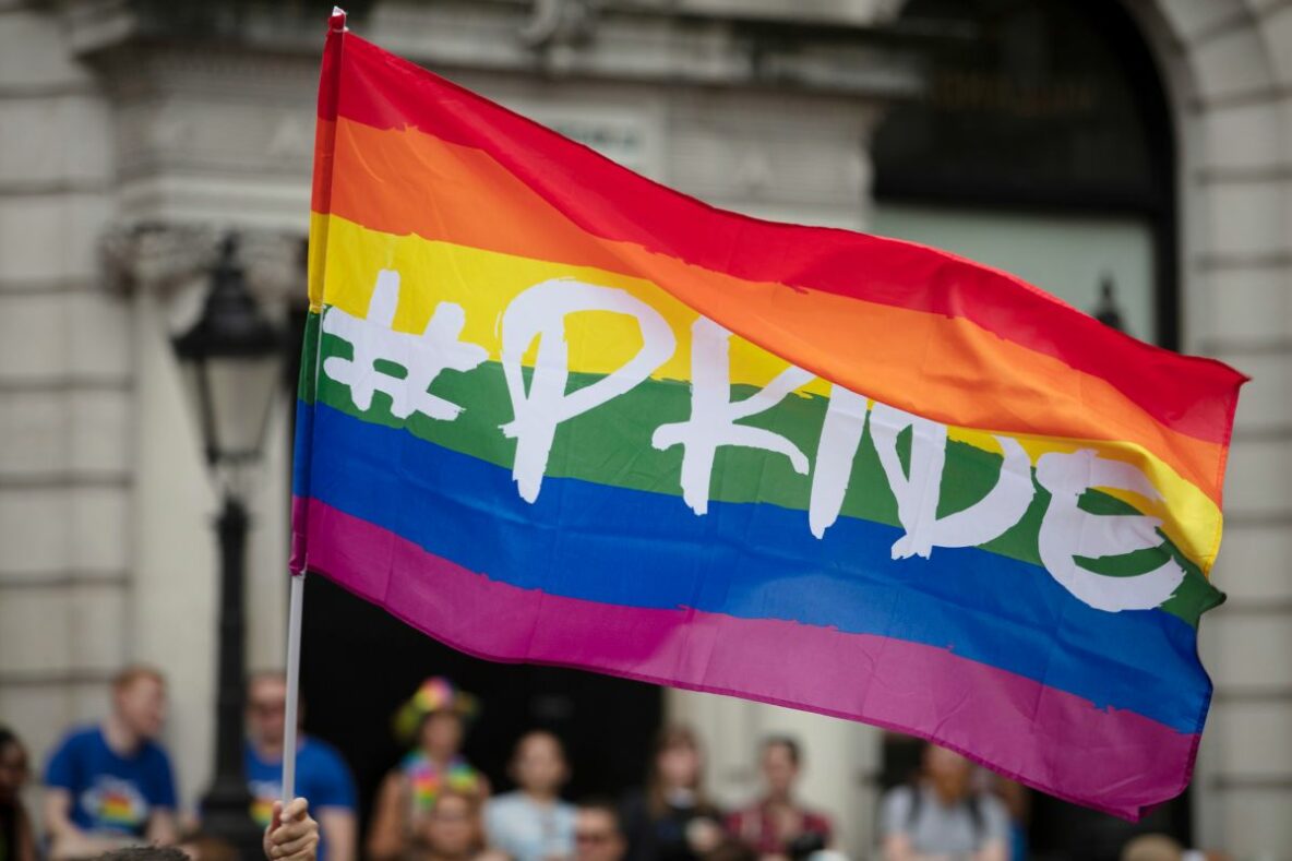 Pride flag with #PRIDE written across it in white