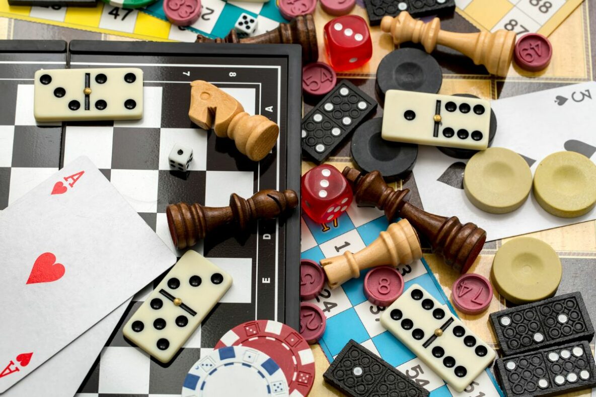 A selection of different board games including playing cards, dominos, chess and playing pieces.